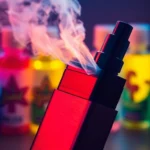 Vape device emitting vapor with colorful e-liquid bottles in the background for vaping enthusiasts
